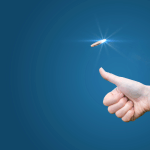 A light-skinned hand tossing a coin on a blue background