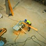 A worker cutting wood on a bench in a workshop