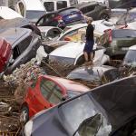Residents look at cars piled up after being swept away by floods in Valencia, Spain, Wednesday, Oct. 30, 2024.