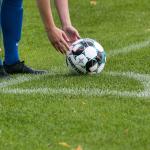 A football player sets up to take a corner kick in 2021