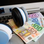 Computer keyboard with headphones and euro bank notes
