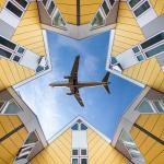Airplane flying above houses.