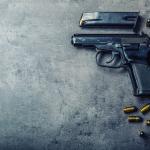 Pistol gun and discharged bullets on the table