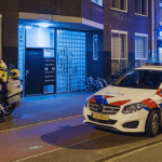 A Dutch police officer, car and motorcycle on an Amsterdam street at night