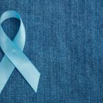 Blue ribbon for prostate cancer awareness on a demin background