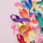 Colorful cancer awareness ribbons on a pink bacground