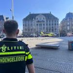 A police officer looks on as a trauma helicopter arrives in Amsterdam after five people were stabbed in the city center. 27 March 2025