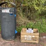 A crate to donate bottles and cans which can be exchanged for a deposit is placed next to a garbage can in the Indische Buurt in Amsterdam. 9 October 2024