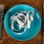 Weight loss concept - tape measure on an empty plate