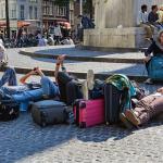 Tourists in Amsterdam laying down on Dam Square while using their smartphones. 9 Sept. 2015
