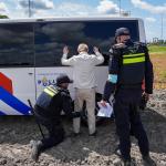 Police search a person during an Extinction Rebellion (XR) protest near the A44 highway in Abbenes, Noord-Holland.