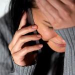 A woman cries while speaking on the phone.