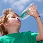 Boy drinking water in the summer heat