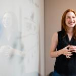 A woman leading a business analysis and consulting presentation in July 2019
