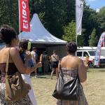 Several women walk with popsicles past a first aid tent during the National Slavery Abolitin Commemoration in Amsterdam. 1 July 2025