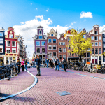 Tourist taking a photo at the bridge over the Singelgracht at the Weide Heisteeg in the historic center of Amsterdam