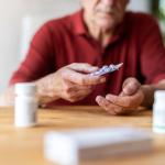 Elderly man is taking medication.