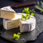 Camembert cheese on dark slate