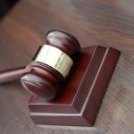 A gavel rests on the desktop of a judge's bench. 
