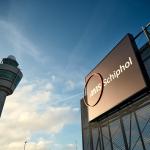 Angled shot showing Amsterdam Airport Schiphol's logo and an air traffic control tower