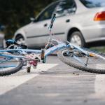 Broken bike, a car after a collision.