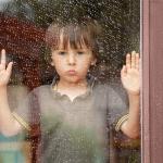 Little boy is waiting for the rain to pass