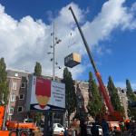 A pre-fabricated residential space being lifted over a poster for the 2025 parliamentary election to be placed as an apartment’s rear garden extension in Amsterdam, 17 October 2025