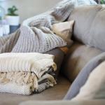 Pillows and blankets stacked on a couch