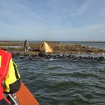 Man next to his self-built tent after spending two days on an uninhabited island on the IJsselmeer.