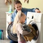 A mother is teaching her daughter how to do laundry