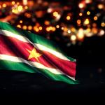 The flag of Suriname against a backdrop of city lights. Artist's rendering. 