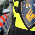 A Dutch police officer standing by a police car