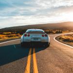 On the road in a silver Nissan GT-R sports coupé. 2019