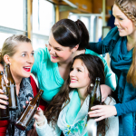 Girlfriends drinking beer on a party bus