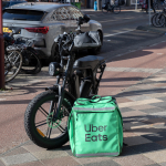 An Uber Eats cargo bag on an Amsterdam street next to a courier's fatbike. March 2025