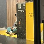 A person takes shelter from the cold wind on Christmas Eve inside a Geldmaat ATM storefront location in Amsterdam. 24 Dec. 2025