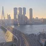 The sun rises behind De Rotterdammer complex and the Erasmus Bridge on a crisp, clear day in Rotterdam. 24 Dec. 2025