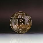 A physical bitcoin standing upright on a table