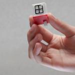 A hand holding a tiny, toy house