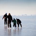A family skates on natural ice