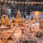 Snow-covered empty outdoor seating at a closed restaurant