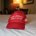 A MAGA campaign hat on a hotel bed 