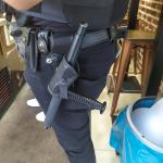 An enforcement officer carrying a baton.