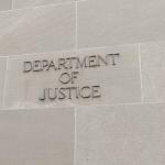 Closeup of sign of US Department of Justice (DOJ) at facade of Robert F. Kennedy Building