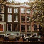 Dark SUV and a BMW wagon parked canal-side on the Reguliersgracht in Amsterdam Centrum. Aug. 2021