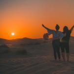 Two women standing in the desert at sunset in Dubai, United Arab Emirates. 2022