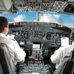 A pilot and co-pilot inside a cockpit.