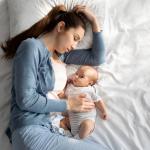 A mother sleeps with her baby