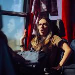 A woman on a train is startled by something.