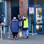 An election monitor escorts a handful of voters into the polling place at the Muiderkerk in Amsterdam-Oost. 18 March 2026